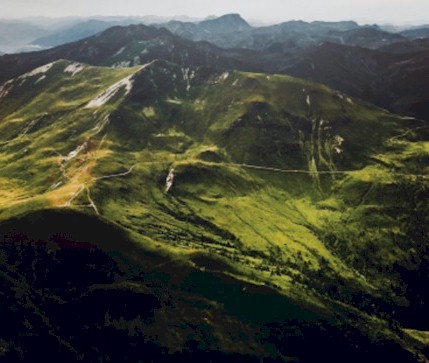 View from the top of a mountain over multiple mountain ridges