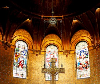 Picture of stained glass windows and a cross in a church