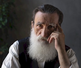 Elderly man looking at the camera whilst thinking