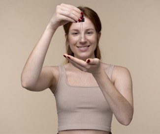 A young woman holding a measuring pipettes above her hand