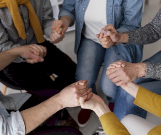A group of people holding hands whilst praying